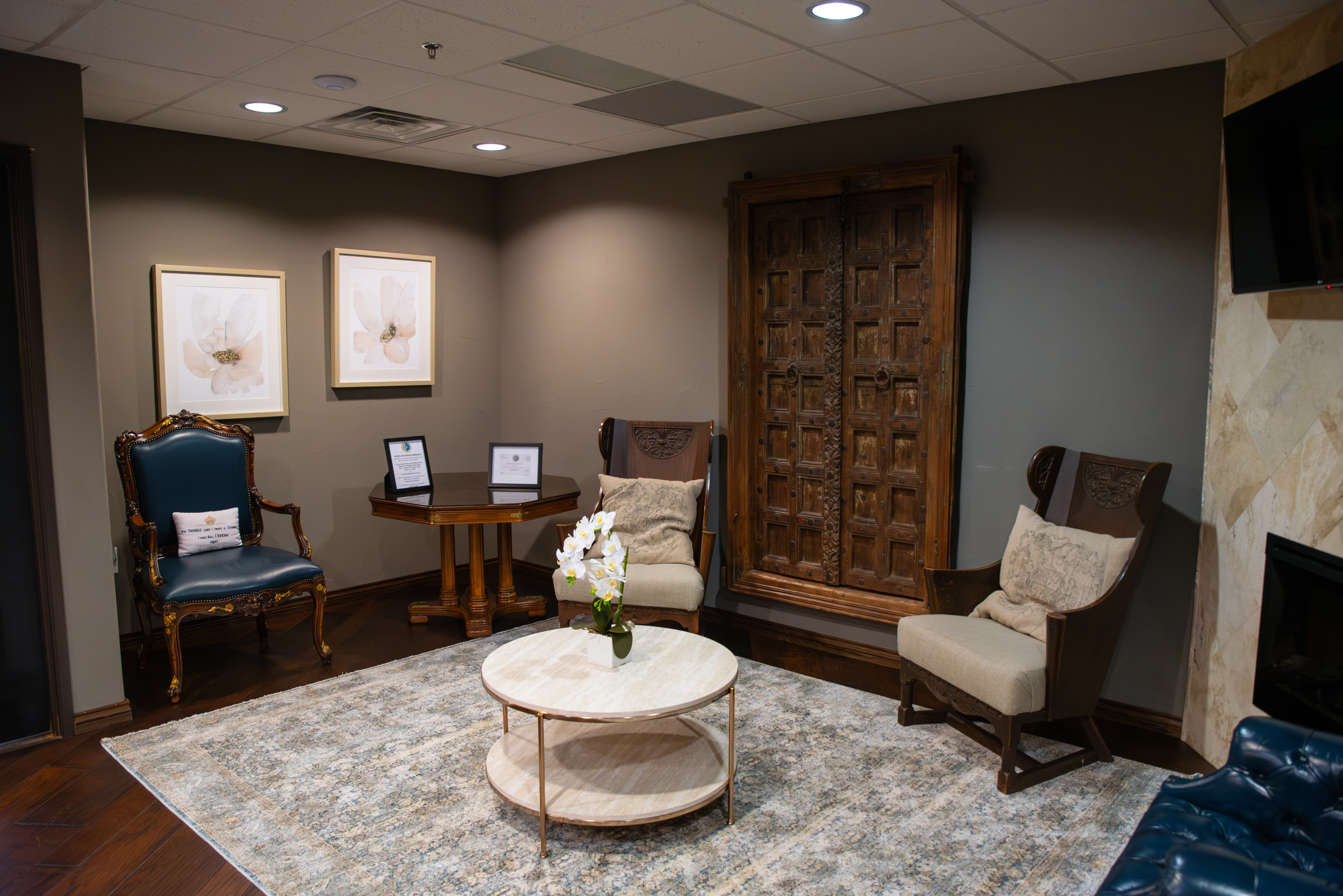 Luminescence Dentistry Waiting room with three elegant wooden chairs and a small beige center table